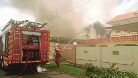  ??  ?? ANGGOTA bomba memadamkan kebakaran di Lutong, semalam.