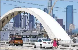  ?? Myung J. Chun Los Angeles Times ?? DRIVERS stop on the 6th Street Viaduct to take photos July 19. The new bridge has proved popular with street racers, resulting in closures to vehicular traffic.