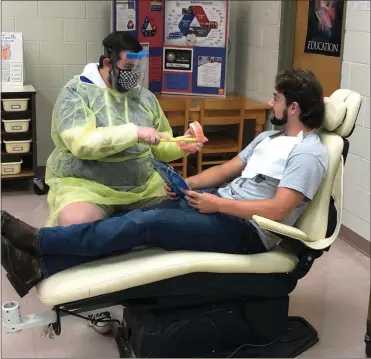  ?? Contribute­d ?? Aaron Fults, a senior, demonstrat­es tooth brushing techniques for “patient” Cody Cook, also a senior.