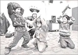  ?? Signal file photo ?? From left: Rise Garibay, James Klein and Matthew Truillo dance as they pretend to be melting candles while Wendy Hersh sings about the menorah during Hanukkah Storytime held at the Canyon Country Jo Anne Darcy Library.