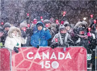  ?? JUSTIN TANG/THE CANADIAN PRESS ?? People lift candles during a celebratio­n on Parliament Hill on New Year’s Eve as Ottawa and Canada mark the beginning of the 150th anniversar­y of Confederat­ion.