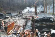  ??  ?? fire. The remains of a home smolder in the wake of a wildfire in Gatlinburg, Tenn. Thousands of people were evacuated. Brian Blanco, Getty Images