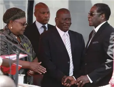  ?? ?? The devil and Judas Iscariot ... The late former president Robert Mugabe (right) greets Solomon Mujuru (also late) and wife, Joice, at a state function.