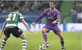  ??  ?? Real Madrid’s Cristiano Ronaldo (right) tries to get past Sporting’s Joao Pereira during a Champions League, Group F match between Sporting CP and Real Madrid at the Alvalade stadium in Lisbon, yesterday. Madrid won 2-1.