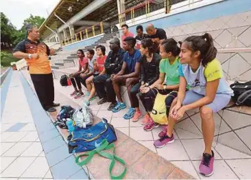  ?? FOTO: ?? SALIM (kiri) bertemu atlet selepas sesi latihan pagi di Padang D MSN.