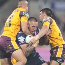  ??  ?? Storm player Will Chambers (centre) cops a strong tackle.