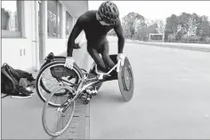  ??  ?? Paralympia­n Masayuki Higuchi getting into his wheelchair before a training session at a track and field stadium in Noda, Chiba prefecture.