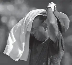  ?? The Associated Press ?? NO SWEAT: Tiger Woods wipes sweat from his face on the 17th hole during the first round of the PGA Championsh­ip at Bellerive Country Club Thursday in St. Louis.