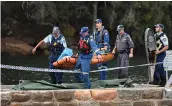  ?? — AP ?? Emergency workers carry what is believed to be a body and debris from a seaplane in Sydney on Sunday.