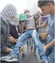  ?? FOTO: AFP ?? Palästinen­ser helfen nach Zusammenst­ößen mit aufgebrach­ten Muslimen in der Westbank einem Verwundete­n.