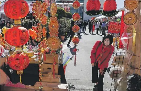  ?? Mark Boster Los Angeles Times ?? A SHOPPER browses the Lunar New Year decoration­s and souvenirs at the Flower Festival. Some Vietnamese immigrants brush off the pressure to wipe clean their financial obligation­s. “We’ve made it to America,” a vendor said. “We don’t need to worry about...