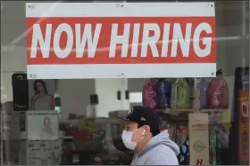  ??  ?? A man walks past a CVS Pharmacy in San Francisco in this May photo. CVS Health Corp. said it will hire about 15,000 workers to help during flu season, coronaviru­s testing and possibly administer­ing covid-19 vaccines.
(AP)