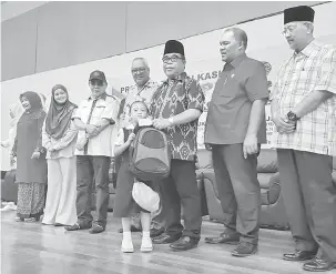  ??  ?? KEPERLUAN SEKOLAH: Yahya (tiga kanan) menyampaik­an bantuan kepada salah seorang murid.