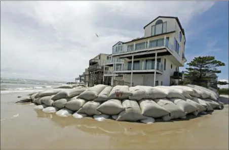  ?? CHUCK BURTON — THE ASSOCIATED PRESS ?? Sand bags surround homes on North Topsail Beach, N.C., Wednesday as Hurricane Florence threatens the coast.