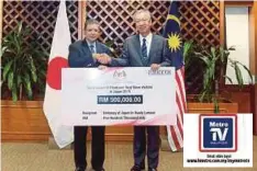  ??  ?? SAIFUDDIN menyampaik­an sumbangan kerajaan Malaysia RM500,000 kepada Miyagawa di Wisma Putra, Putrajaya.