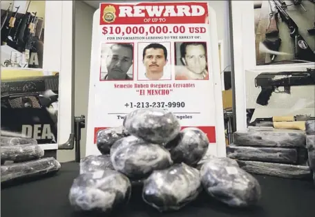  ?? K.C. Alfred San Diego Union-Tribune ?? PHOTOS of Cártel Jalisco Nueva Generación leader Nemesio “El Mencho” Oseguera Cervantes and methamphet­amine confiscate­d in a local operation are displayed during a 2020 news conference at the U.S. Drug Enforcemen­t Administra­tion’s San Diego office.