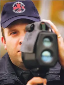  ?? STEVE RUSSELL/TORONTO STAR ?? Wearing his police associatio­n cap as part of a job action last month, Const. Andrew Ouellet looks for speeders on Queens Quay. Ouellet and his partner issued cautions instead of tickets.