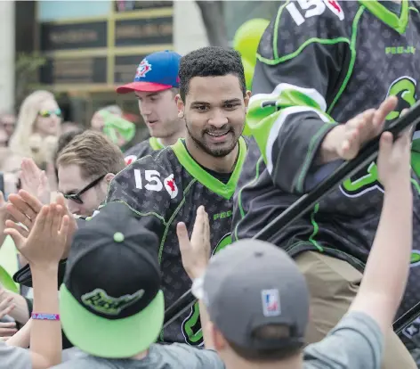  ?? LIAM RICHARDS ?? Jeff Cornwall high-fives fans during the Rush rally on Friday in downtown Saskatoon. Players chatted with fans while posing for photos and signing autographs, as excitement builds toward Saturday night’s playoff date with the Colorado Mammoth at the...