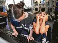  ??  ?? Ava Sophia, 9, reacts to the challenge of navigating to the moon during a simulated mission at the museum.