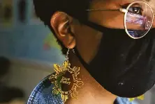  ??  ?? Sasa Ramos, a junior, wears earrings that read “Know History” at the club focused on Latin American culture.