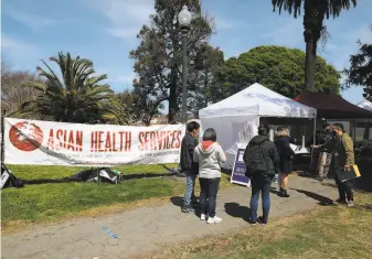  ?? Photos by Lea Suzuki / The Chronicle ?? Asian Health Services, sponsoring this Oakland vaccinatio­n clinic, leads a coalition setting up a website to spotlight language barriers that hinder access to coronaviru­s vaccines.