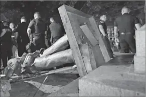  ?? Associated Press ?? ■ Police stand guard Monday after the Confederat­e statue known as “Silent Sam” was toppled by protesters on campus at the University of North Carolina in Chapel Hill.