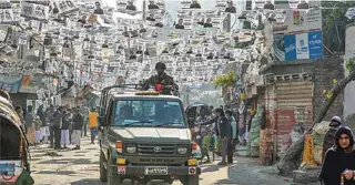  ?? - AFP ?? PATROLLING: Bangladesh­i army personnel drive a military vehicle through a street adorned with election posters near a polling station in Dhaka on December 30, 2018.