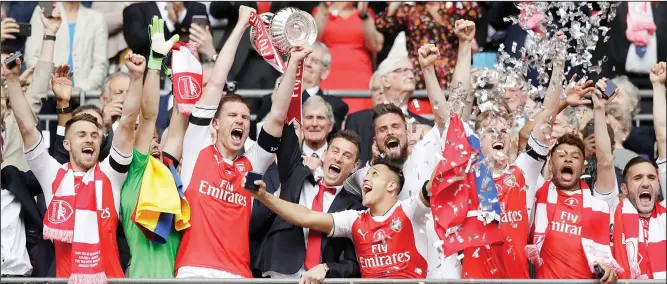  ??  ?? Arsenal’s players celebrate with the trophy after winning the English FA Cup final soccer match between Arsenal and Chelsea at the Wembley Stadium in London on May 27. (AP)