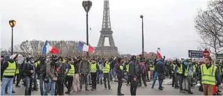  ?? - AFP file photo ?? PROTEST AGAINST RISING OIL PRICES: Protestors wearing “yellow vests” stand near the river Seine as the Eiffel tower is seen, during a protest of against rising oil prices and living costs.