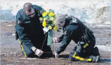  ?? JONATHAN HAYWARD THE CANADIAN PRESS ?? Members of the RCMP lay flowers Sunday at the intersecti­on of the crash site near Tisdale, Sask.