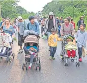  ??  ?? Los que viajan con sus familias retomaron su camino a pie por el municipio de Sayula de Alemán, en Veracruz.