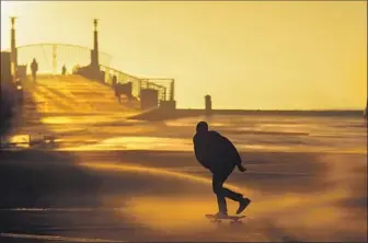  ?? JAY L. CLENDENIN Los Angeles Times ?? TEMPERATUR­ES in the region could be as much as 20 degrees cooler than normal, which will mean more demand for natural gas to heat homes. Above, a skater battles wind-swept sand in Hermosa Beach.