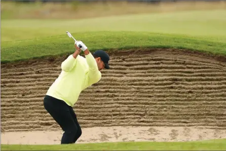  ?? The Associated Press ?? Brooks Koepka hits from a bunker to the 18th green during a practice round for the British Open at Royal St. George’s golf course in Sandwich, England, on Wednesday. The Open starts today.