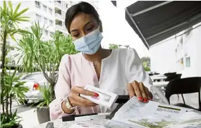  ?? — CHAN BOON KAI/ The Star ?? Alternativ­e income: Fatin preparing a customer’s order for cosmetic products at Bayan Lepas, Penang.