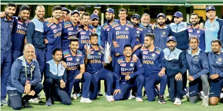  ?? AP ?? Members of the Indian team pose with the winner’s trophy after the third T20 against Australia at the Sydney Cricket Ground on Tuesday. Also seen in the pic are team manager Girish Dongre (front row, left) and fielding coach R. Sridhar (front row, third from right) of Hyderabad. —