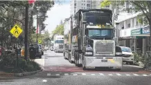  ?? Picture: GLENN HAMPSON ?? Supercars arrive via a truck convoy along Tedder Ave, Main Beach.