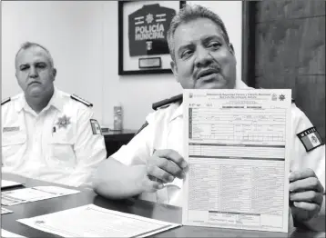  ?? PHOTO BY CESAR NEYOY/BAJO EL SOL ?? HECTOR CHAVEZ, THE TRAFFIC POLICE CHIEF IN SAN LUIS RIO COLORADO, SON., shows a new traffic warning form that police will give to motorists in lieu of a fine for minor traffic violations.