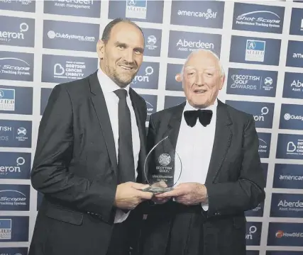  ??  ?? 0 Martin Dempster presents Jock Macvicar with a lifetime achievemen­t accolade at the Scottish Golf Awards in 2017