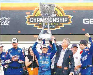  ?? The Associated Press ?? Kyle Larson, center, celebrates after winning the NASCAR Cup Series championsh­ip on Nov. 7 in Avondale, Ariz.