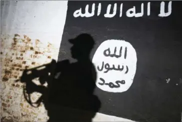  ?? AHMAD AL-RUBAYE/AFP ?? A member of the Iraqi forces walks past a mural bearing the logo of Islamic State in a tunnel that was reportedly used as a training centre by the jihadists, on March 1, outside Mosul.