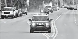  ?? TONY GIBERSON/PENSACOLA NEWS JOURNAL ?? Police cars escort an ambulance after a shooter opened fire last week at the Pensacola Naval Air Station in Florida. A Saudi air force officer shot and killed three people.