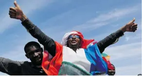  ?? SIA KAMBOU/THE ASSOCIATED PRESS ?? Youths celebrate with the French flag Tuesday in the Malian town of Ansongo, which French-led soldiers recaptured from radicals holding the country’s north over the weekend.