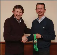  ??  ?? Bill Porter presents the Leinster mens bronze masters over-35 medals to Damien Byrne from Kilcoole AC on behalf of his team mates Colin Wendell and Brian Gurrin.