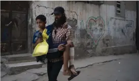  ?? FOTO: FELIPE DANA/TT-AP ?? ■
En tolvårig pojke bärs av sin pappa sedan han blivit vårdad på ett sjukhus i Gaza city. Pojken sköts i benet av en israelisk krypskytt sedan han protestera­t intill gränsen till Israel. Bilden är från 2018.