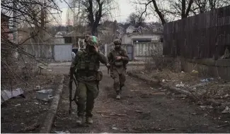  ?? ?? Ukrainian soldiers walk along a street in the area of the heaviest battles with the Russian invaders in Bakhmut, Donetsk region, Ukraine, Wednesday, 15 March, 2023.