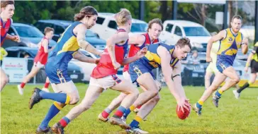  ??  ?? Ellinbank’s Mark Vassett scoops up the ball ahead of the pack during the final quarter; Photograph­s: Craig Johnson.