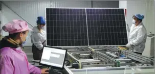  ?? PROVIDED TO CHINA DAILY ?? Employees assemble photovolta­ic panels at a production facility in Liupanshui, Guizhou province.