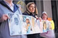  ?? MATT ROURKE/ASSOCIATED PRESS ?? During a news conference in Philadelph­ia in 2011, Barbara Blaine displays childhood photos of adults who say they had been sexually abused by members of the clergy.