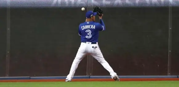  ?? RICHARD LAUTENS/TORONTO STAR ?? Blue Jays left fielder Ezequiel Carrera mishandles a ball hit off the wall by Cleveland’s Mike Napoli in the first inning of Game 5, allowing the first run to score.