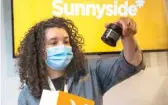  ?? ASHLEE REZIN GARCIA/SUN-TIMES ?? Jordan Davis, a wellness adviser, shows products to a customer at Cresco Labs’ seventh Sunnyside dispensary at 436 N. Clark St. in May.